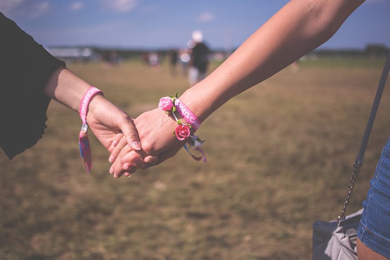friends hold hands as an example of supporting a loved one with an eating disorder