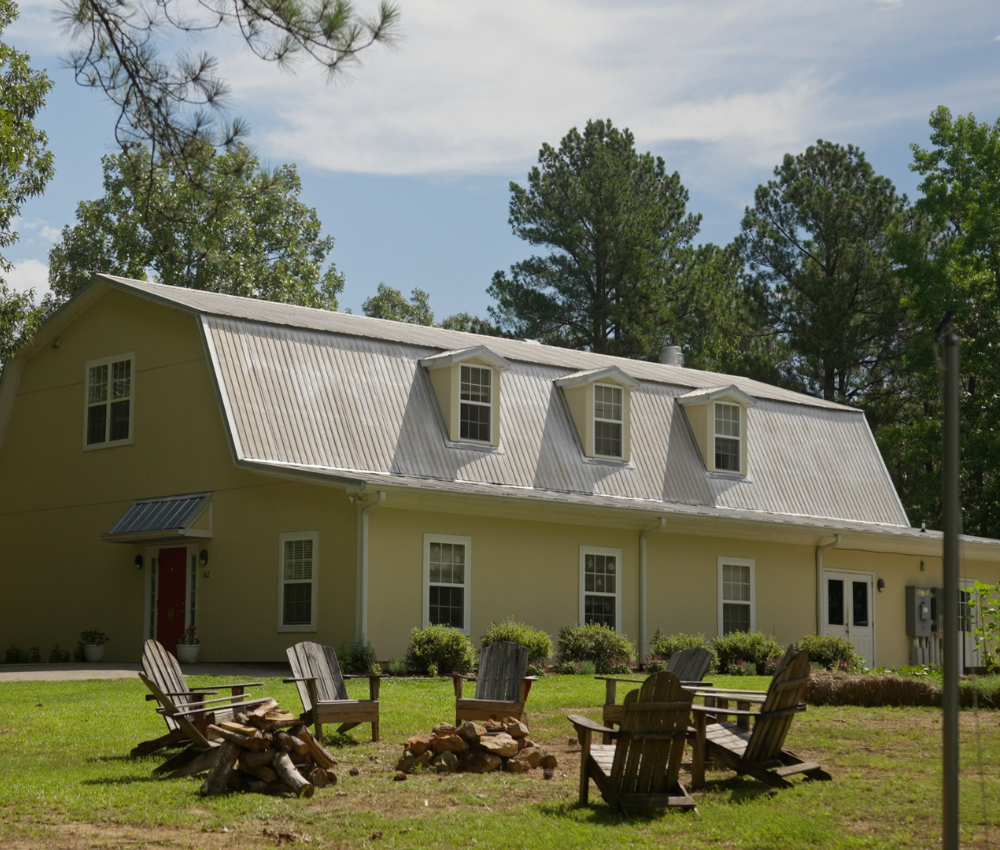 Exterior of barn with firepit and chairs